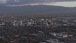 6K aerial stock footage of a reverse view of city buildings in Downtown San Jose at sunset, California Aerial Stock Footage | AX0174_0042