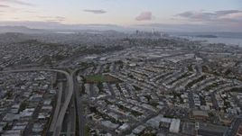 6K aerial stock footage tilt from 101 freeway to reveal the distant San Francisco skyline at sunset, California Aerial Stock Footage | AX0174_0075