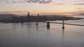 6K aerial stock footage a wide view of the Bay Bridge and the Downtown San Francisco skyline at sunset, California Aerial Stock Footage | AX0174_0087