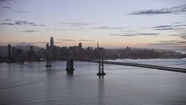 6K aerial stock footage fly away from Downtown San Francisco skyline, seen from Bay Bridge at twilight, California Aerial Stock Footage | AX0174_0113