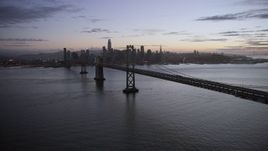 6K aerial stock footage of following the Bay Bridge toward the Downtown San Francisco skyline at twilight, California Aerial Stock Footage | AX0174_0115
