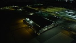 6K aerial stock footage of a hangar at Oakland Airport at night, California Aerial Stock Footage | AX0174_0125