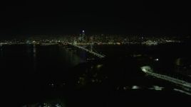 6K aerial stock footage ascend over Yerba Buena Island, reveal Bay Bridge and Downtown San Francisco at night, California Aerial Stock Footage | AX0174_0136
