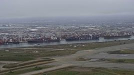 6K aerial stock footage flying past cargo ships docked at the Port of Oakland, California Aerial Stock Footage | AX0175_0079