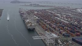 6K aerial stock footage of cargo ships docked under cranes at the Port of Oakland, California Aerial Stock Footage | AX0175_0081