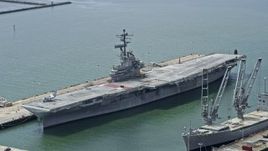 6K aerial stock footage of an aircraft carrier docked in Alameda, California Aerial Stock Footage | AX0175_0100