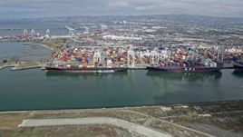 6K aerial stock footage of passing cargo ships docked at the Port of Oakland, California Aerial Stock Footage | AX0175_0101