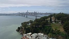 6K aerial stock footage ascend over Yerba Buena Island, reveal Bay Bridge and Downtown San Francisco, California Aerial Stock Footage | AX0175_0114