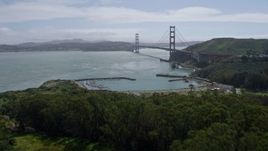 6K aerial stock footage fly over trees on the shore to reveal the Golden Gate Bridge, San Francisco, California Aerial Stock Footage | AX0175_0173
