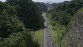 4.8K aerial stock footage Following traffic along a highway through lush green mountains, Karst Forest, Puerto Rico Aerial Stock Footage | AX101_081