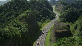 4.8K aerial stock footage Following traffic along a highway through lush green mountains, Karst Forest, Puerto Rico Aerial Stock Footage | AX101_081E