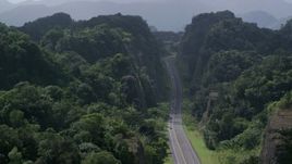 4.8K aerial stock footage Flying above highway cutting through lush green mountains, Karst Forest, Puerto Rico Aerial Stock Footage | AX101_085