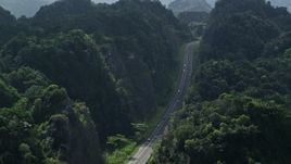 4.8K aerial stock footage Flying above highway cutting through lush green mountains, Karst Forest, Puerto Rico Aerial Stock Footage | AX101_085E