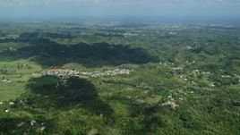 4.8K aerial stock footage of Rural homes situated among lush green trees in Karst mountains, Arecibo, Puerto Rico Aerial Stock Footage | AX101_124E