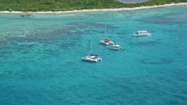4.8K aerial stock footage of catamarans in tropical blue waters with reefs near an island, Rada Fajardo, Puerto Rico Aerial Stock Footage | AX102_073E