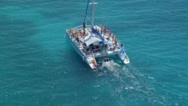4.8K aerial stock footage Flying away from a catamaran in tropical blue water, Rada Fajardo, Puerto Rico Aerial Stock Footage | AX102_077