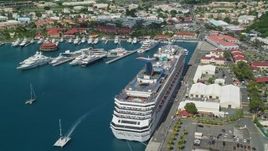 4.8K aerial stock footage of a cruise ship and yachts in sapphire waters along a coastal town, Charlotte Amalie, St. Thomas Aerial Stock Footage | AX102_209E