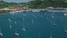 4.8K aerial stock footage of Sailboats and cruise ship in sapphire blue waters along the coast, Charlotte Amalie, St Thomas Aerial Stock Footage | AX102_230