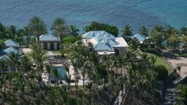 4.8K aerial stock footage of an Oceanfront mansion and palm trees, Little St James Island, St Thomas Aerial Stock Footage | AX102_252