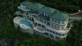 4.8K aerial stock footage of a hillside oceanfront mansion with a pool, Northside, St Thomas Aerial Stock Footage | AX102_264E