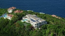 4.8K aerial stock footage of hilltop mansions looking out toward sapphire blue Caribbean waters, Magens Bay, St Thomas Aerial Stock Footage | AX102_285E