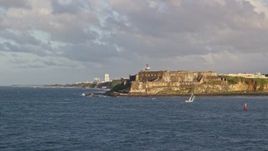 4.8K aerial stock footage of Fort San Felipe del Morro along Caribbean blue waters, Old San Juan, sunset Aerial Stock Footage | AX104_013