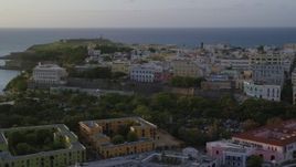4.8K aerial stock footage of La Fortaleza among Caribbean buildings, Old San Juan, sunset Aerial Stock Footage | AX104_034