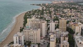 4.8K aerial stock footage of beachfront hotels and Caribbean blue waters, San Juan, Puerto Rico, sunset Aerial Stock Footage | AX104_065E