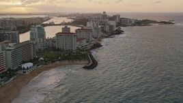 4.8K aerial stock footage of beachfront Caribbean hotels along the ocean, San Juan, Puerto Rico, sunset Aerial Stock Footage | AX104_069E