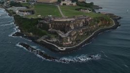 4.8K aerial stock footage of Fort San Felipe del Morro along Caribbean blue waters, Old San Juan, twilight Aerial Stock Footage | AX104_084