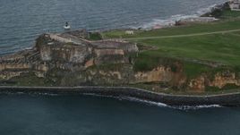 4.8K aerial stock footage of Fort San Felipe del Morro and Caribbean blue ocean waters, Old San Juan, twilight Aerial Stock Footage | AX104_085
