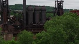 4.8K aerial stock footage clear the Railroad Bridge to approach and flyby Carrie Furnace, Pittsburgh, Pennsylvania Aerial Stock Footage | AX105_034E