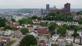 4.8K aerial stock footage of hillside homes revealing downtown skyscrapers, Downtown Pittsburgh, Pennsylvania Aerial Stock Footage | AX105_118E
