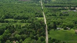 4.8K aerial stock footage of a country road by farms in Garrettsville, Ohio Aerial Stock Footage | AX106_144E