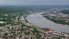 4.8K aerial stock footage of a bridge spanning a river along a town, Monaca, Ohio River, Pennsylvania Aerial Stock Footage | AX107_135