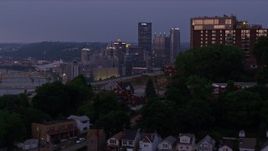4K aerial stock footage flying over hilltop neighborhoods toward Downtown Pittsburgh skyline, Pennsylvania, twilight Aerial Stock Footage | AX108_108E