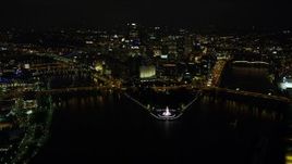 4K aerial stock footage flying over Point State Park Fountain toward Downtown Pittsburgh, Pennsylvania, night Aerial Stock Footage | AX108_235E
