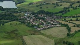 5.5K aerial stock footage of rural homes surrounded by green, Banton, Scotland Aerial Stock Footage | AX109_003