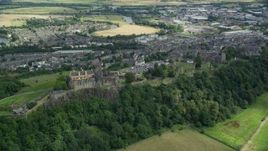 5.5K aerial stock footage of Stirling Castle on a tree covered hill, Scotland Aerial Stock Footage | AX109_037