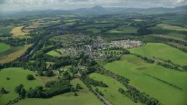 5.5K aerial stock footage approach rural village beside green farmland, Scotland Aerial Stock Footage | AX109_065