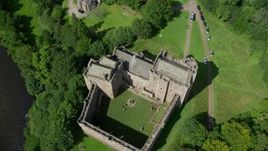 5.5K aerial stock footage of tilting to a bird's eye view of historic Doune Castle and its grounds, Scotland Aerial Stock Footage | AX109_072