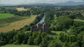 5.5K aerial stock footage fly over Doune Castle and River Teith line with trees, Scotland Aerial Stock Footage | AX109_076E
