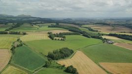 5.5K aerial stock footage of flying over farm fields and trees, Doune, Scotland Aerial Stock Footage | AX109_089E