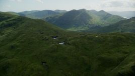5.5K aerial stock footage of ponds on a green mountain ridge, Scottish Highlands, Scotland Aerial Stock Footage | AX110_063