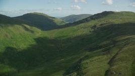5.5K aerial stock footage of flying toward lush green mountains, Scottish Highlands, Scotland Aerial Stock Footage | AX110_092E