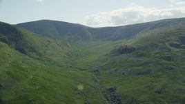 5.5K aerial stock footage of passing lush green mountains, Scottish Highlands, Scotland Aerial Stock Footage | AX110_100