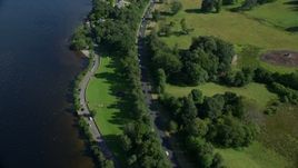 5.5K aerial stock footage fly over A82 Highway along the water and through trees, Alexandria, Scotland Aerial Stock Footage | AX110_127E