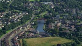 5.5K aerial stock footage approach small bridge on River Leven through residential neighborhood, Alexandria, Scotland Aerial Stock Footage | AX110_133