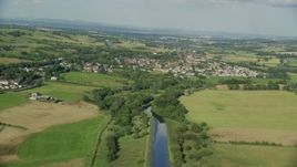 5.5K aerial stock footage of a river and green farm fields around a rural village, Bonnybridge, Scotland Aerial Stock Footage | AX111_002
