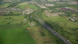 5.5K aerial stock footage approach M80 Highway through farmland and a village, Bonnybridge, Scotland Aerial Stock Footage | AX111_003